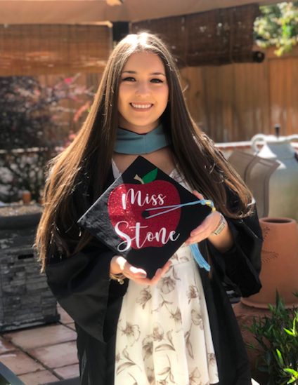 Miss Stone stands with her graduation cap for her Masters degree